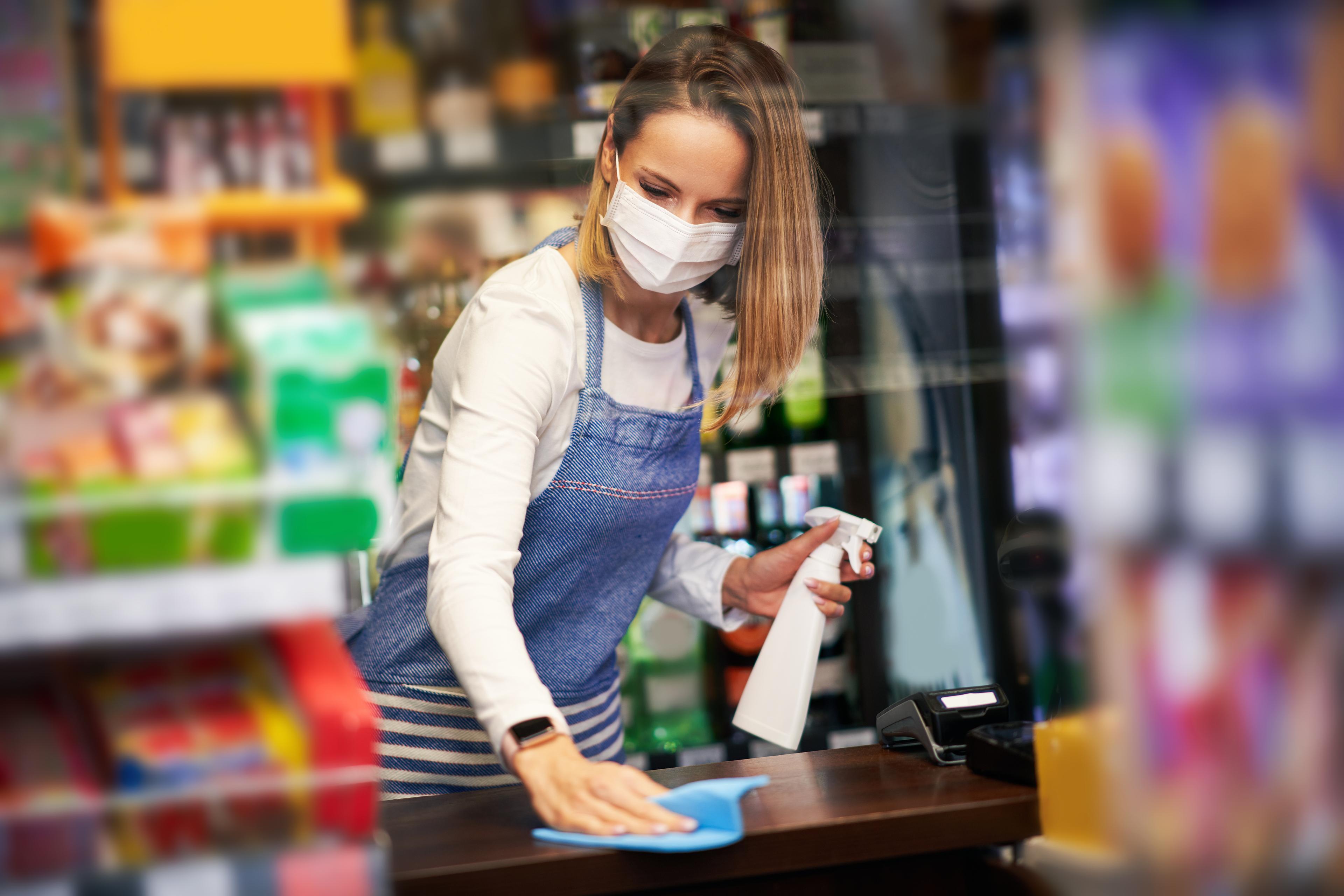retail staff member cleaning register area